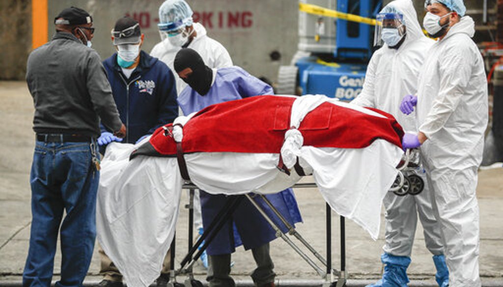 A body wrapped in plastic that was unloaded from a refrigerated truck is handled by medical workers wearing personal protective equipment on March 31, 2020, at Brooklyn Hospital Center in New York City. (AP)