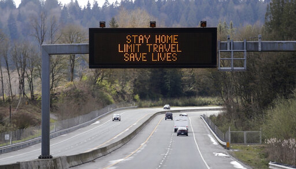 A sign overhead on an unusually quiet highway reminds drivers to "Stay home, limit travel, save lives" as part of Washington Gov. Jay Inslee's ongoing stay-at-home order in the midst of the coronavirus, April 1, 2020, in Monroe, Wash. (AP/Elaine Thompson)