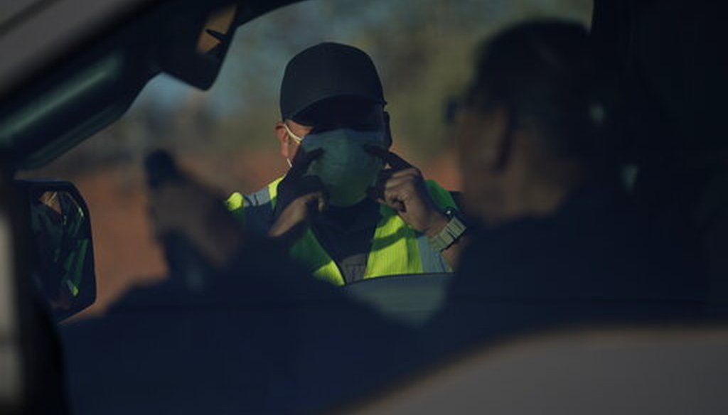 An officer with the Navajo Nation Police talks to a driver at a roadblock in Tuba City, Ariz., on the Navajo reservation on April 22, 2020. (AP/Carolyn Kaster)