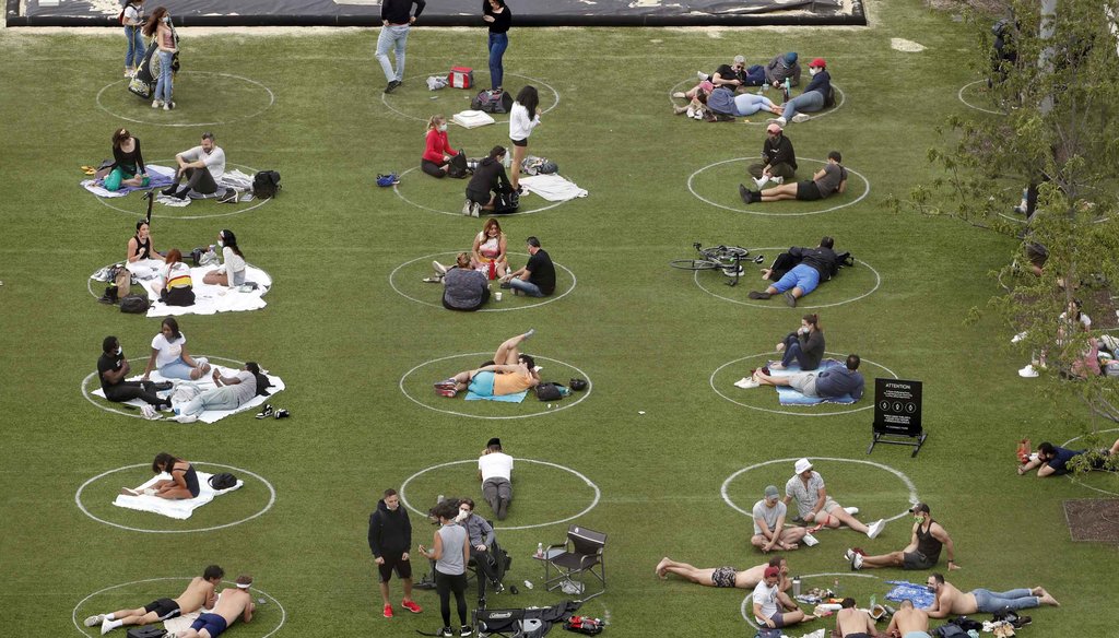 People relax in marked circles for proper social distancing at Domino Park in the Williamsburg neighborhood of Brooklyn during the current coronavirus outbreak on May 17, 2020, in New York. (AP)