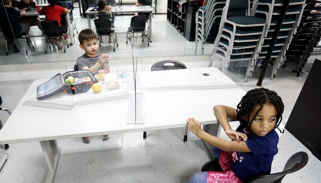 Plastic barriers are placed between children as they sit at a table during martial arts daycare summer camp at Legendary Blackbelt Academy in Richardson, Texas on May 19, 2020. (Associated Press)