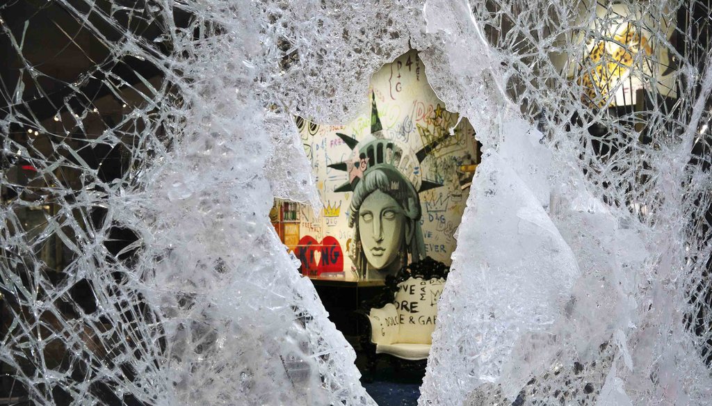 A Statue of Liberty painting is seen through a smashed Dolce and Gabbana store window on June 1, 2020, in the SoHo neighborhood of New York. (AP)