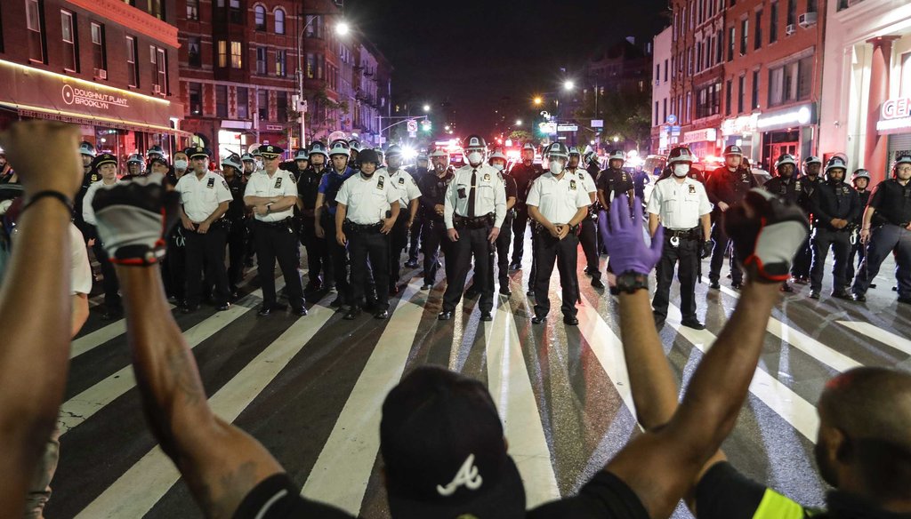 Protesters take a knee on Flatbush Avenue in front of New York City police officers during a solidarity rally for George Floyd on June 4, 2020, in the Brooklyn borough of New York. (AP)