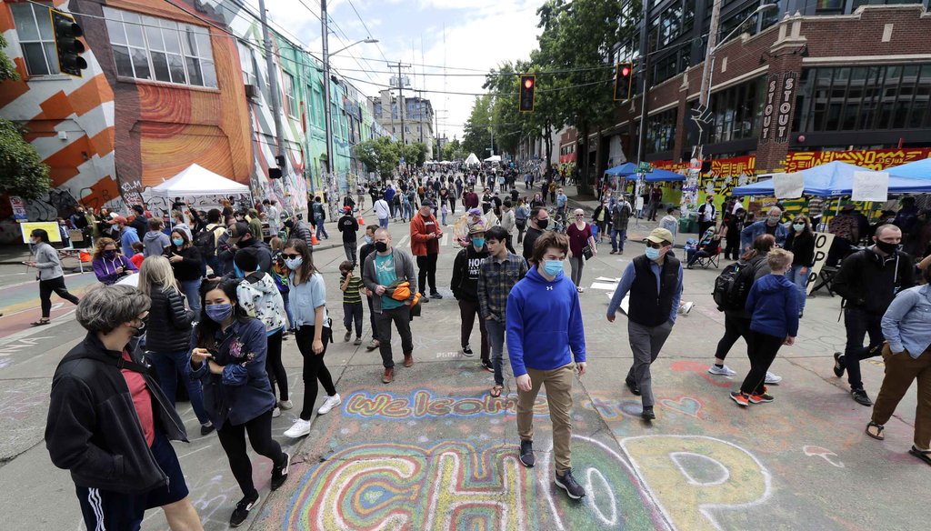 Visitors walk near a sign that reads "Welcome to CHOP" on June 14, 2020, inside what has been named the Capitol Hill Occupied Protest zone in Seattle. (AP)