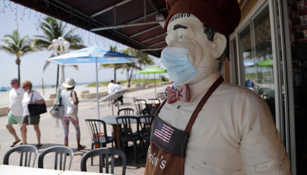 A statue of a chef at Florio's of Little Italy restaurant wears a protective face mask on the Hollywood Beach Broadwalk during the new coronavirus pandemic, Thursday, July 2, 2020, in Hollywood, Fla. (AP Photo)