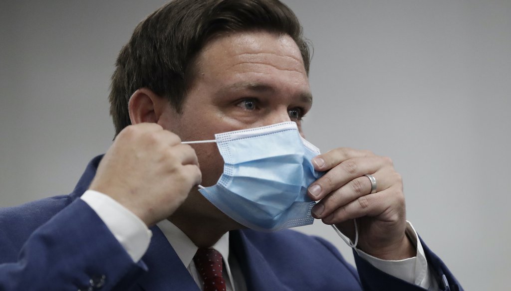 Florida Gov. Ron DeSantis puts on his mask as he leaves a news conference at Jackson Memorial Hospital, Monday, July 13, 2020, in Miami. (AP Images)