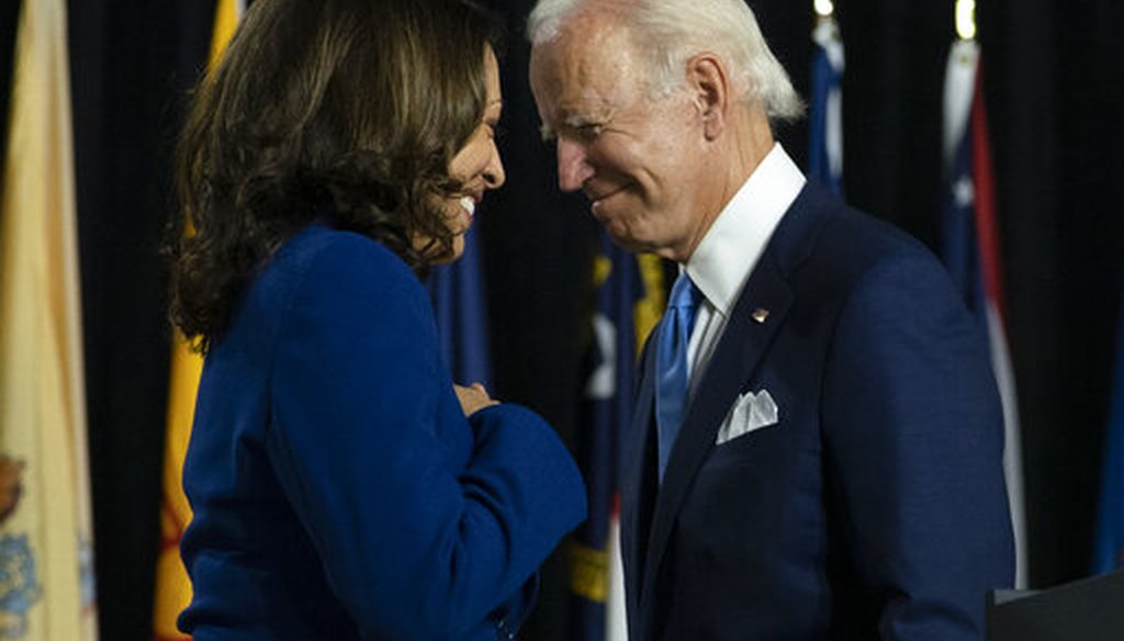 Democratic presidential candidate Joe Biden and his running mate, Sen. Kamala Harris, D-Calif., pass each other as Harris moves to the podium to speak during a campaign event in Delaware, Aug. 12, 2020 (AP)