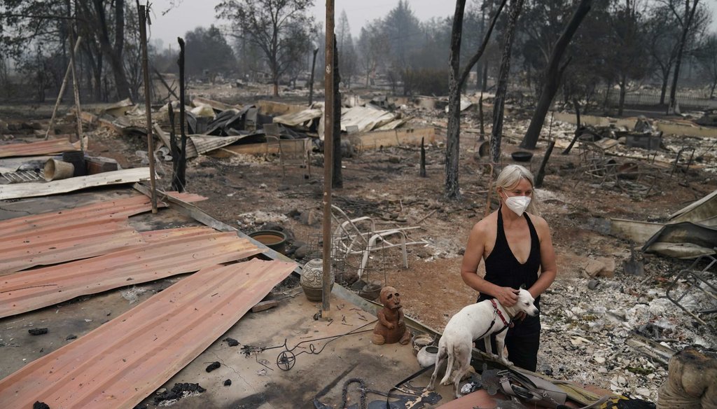 Eden McCarthy pets her dog Hina in the rubble of her home destroyed by the Almeda Fire on Sept. 10, 2020, in Talent, Ore. (AP)