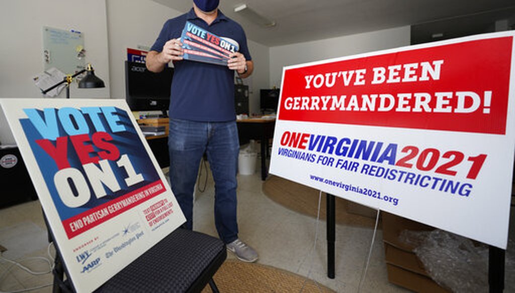 Redistricting reform advocate Brian Cannon poses with some of his yard signs on Oct. 6, 2020, in Richmond, Va. (AP)