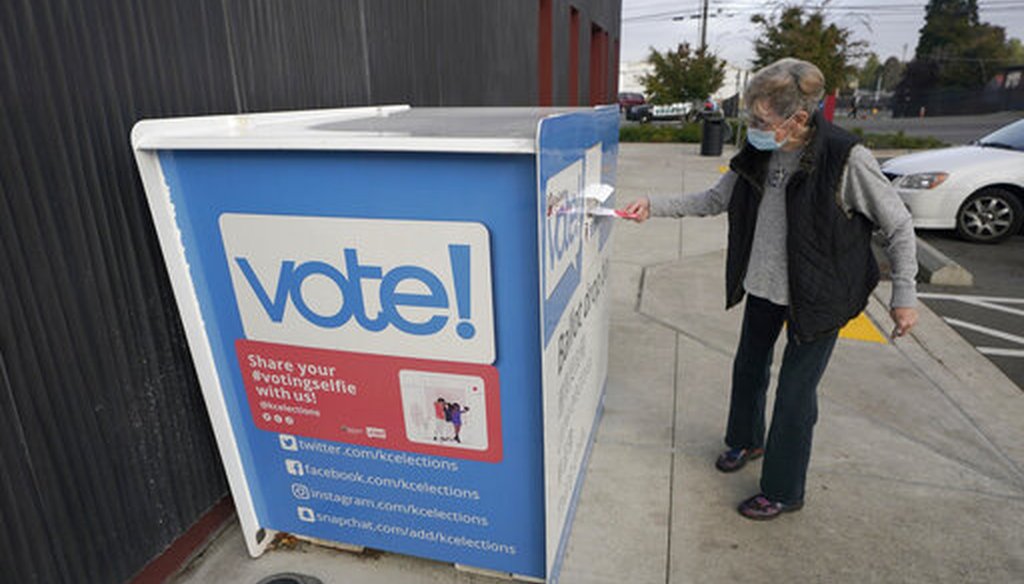 A woman puts a ballot in a drop box on Oct. 27, 2020, at a library in Seattle. (AP)