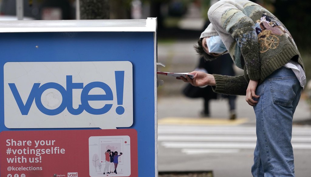 A voter eyes the opening of a ballot drop box before placing his ballot inside it on Oct. 28, 2020, in Seattle. (AP)