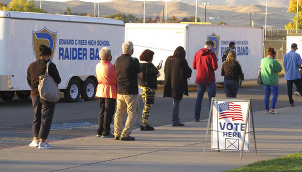 About 100 mostly masked northern Nevadans were waiting to vote in person at Reed High School in Sparks along the eastern front of the Sierra about two hours before the polls closed, Nov. 3, 2020. (AP)