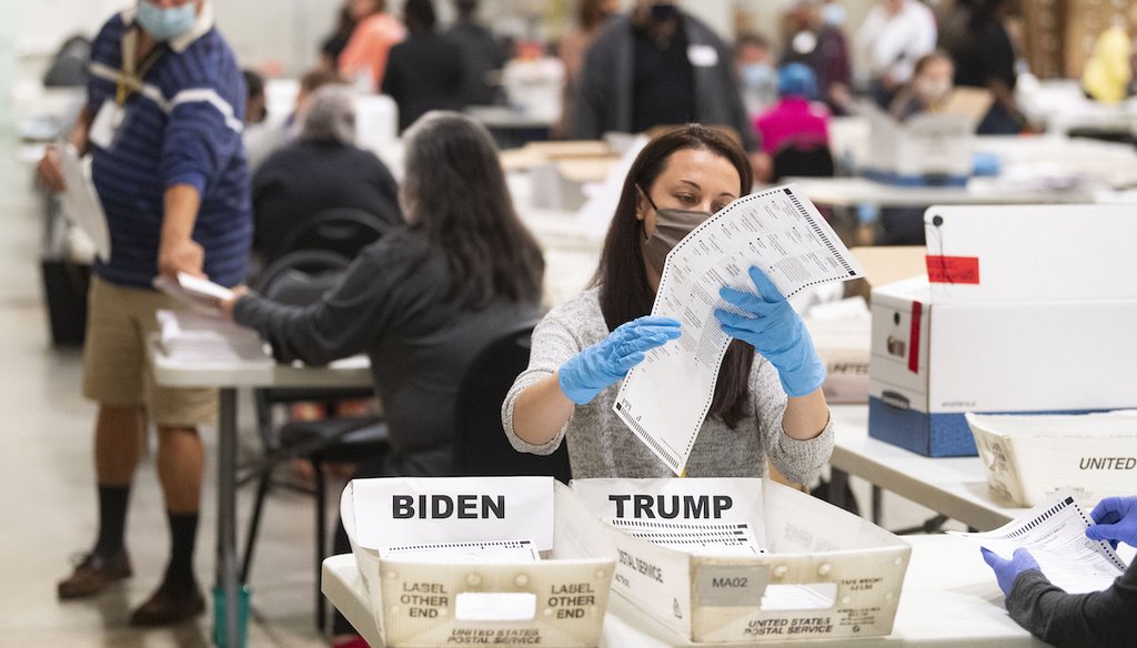 An election worker looks at a ballot during a Cobb County hand recount of presidential votes on Nov.15, 2020, at the Miller Park Event Center in Marietta, Ga. (Atlanta Journal-Constitution via AP)