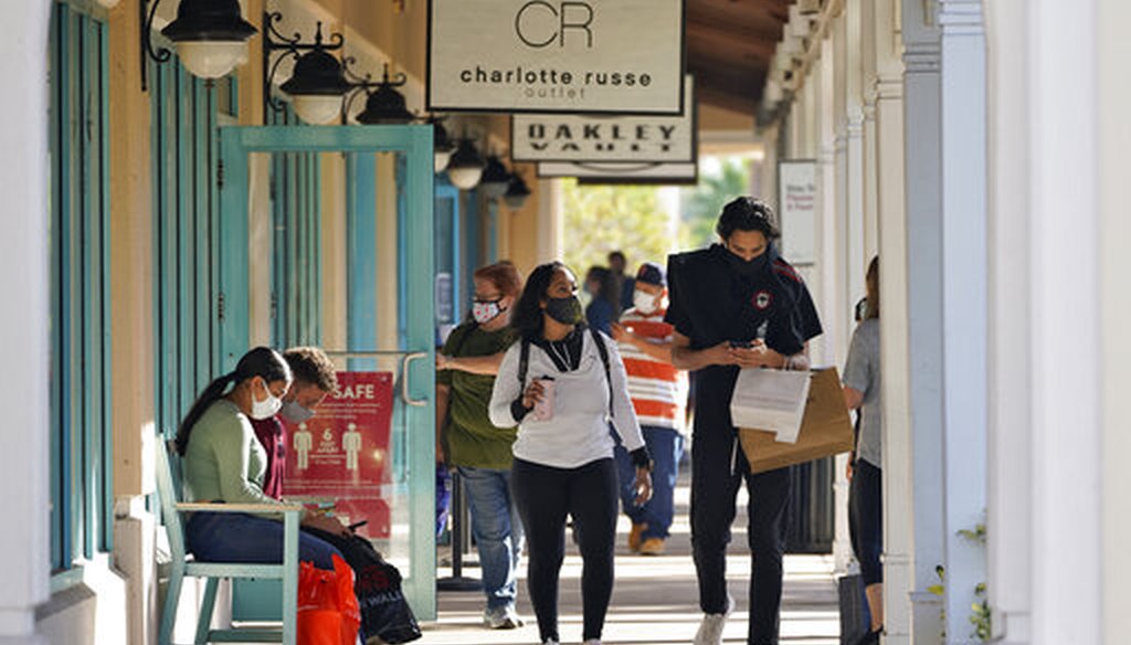 Shoppers wear protective face masks as they look for Black Friday deals at the Ellenton Premium Outlet stores on Nov. 27, 2020, in Ellenton, Fla. (AP)
