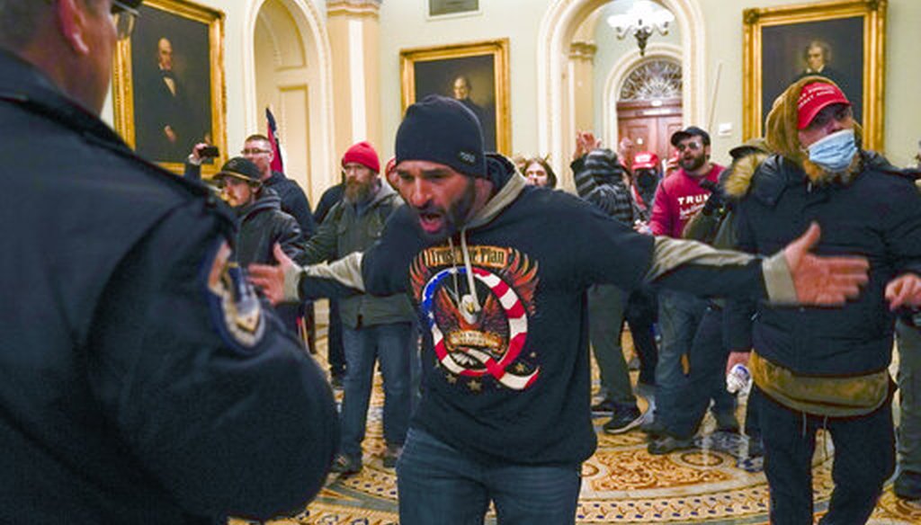 Trump supporters gesture to U.S. Capitol Police in the hallway outside of the Senate chamber on Jan. 6, 2021. (AP/Manuel Balce Ceneta)