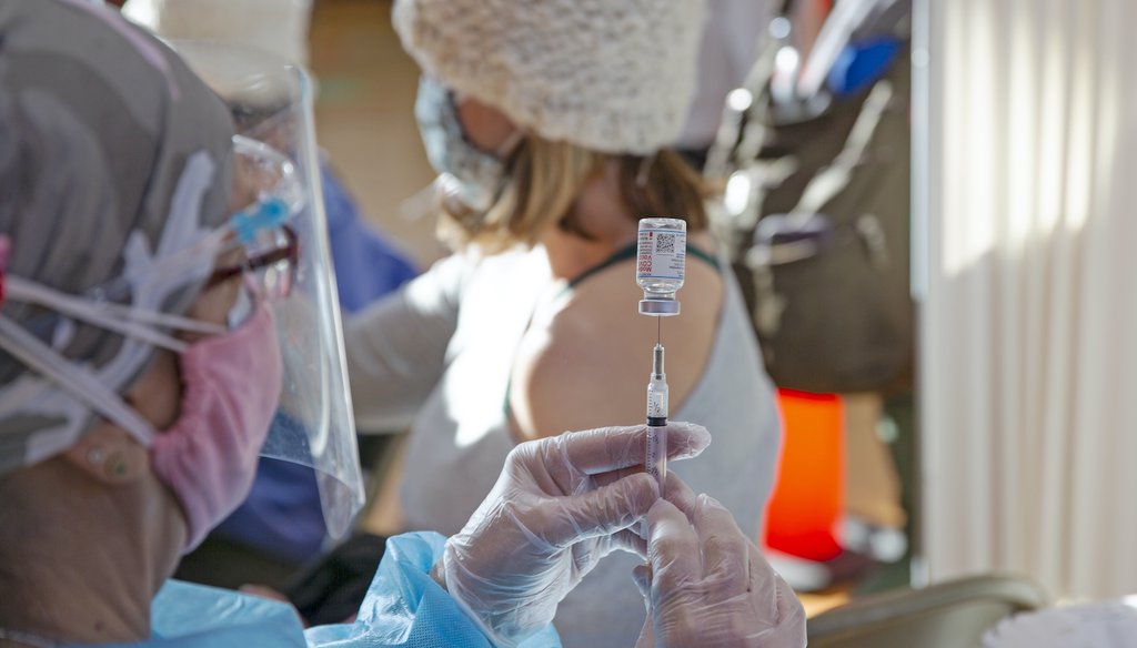 A woman prepares a dose of the Moderna COVID-19 vaccine. (AP Images)