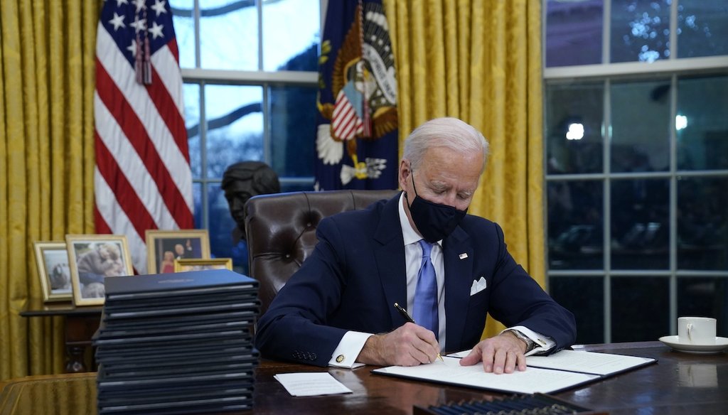 President Joe Biden signs his first executive order in the Oval Office of the White House on Jan. 20, 2021, in Washington. (AP)