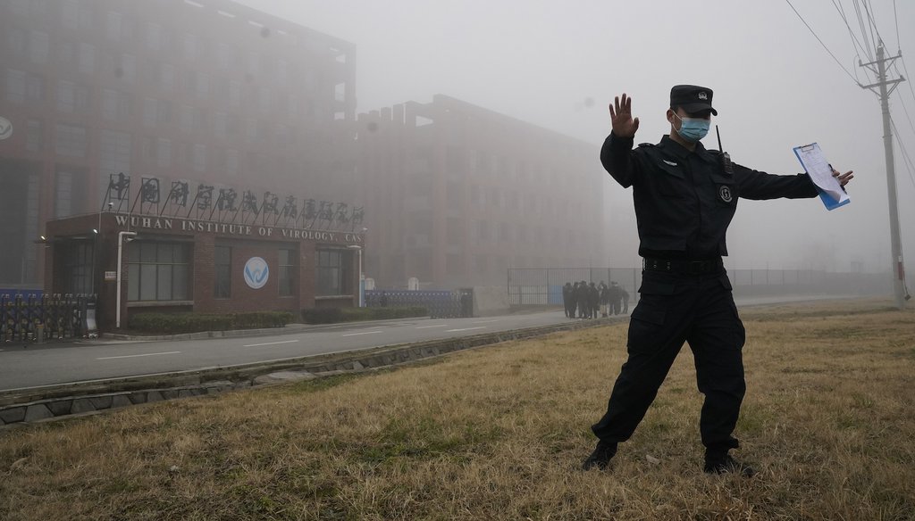 A security official moves journalists away from the Wuhan Institute of Virology after a World Health Organization team arrived for a field visit in Wuhan in China's Hubei province on Wednesday, Feb. 3, 2021. (AP)