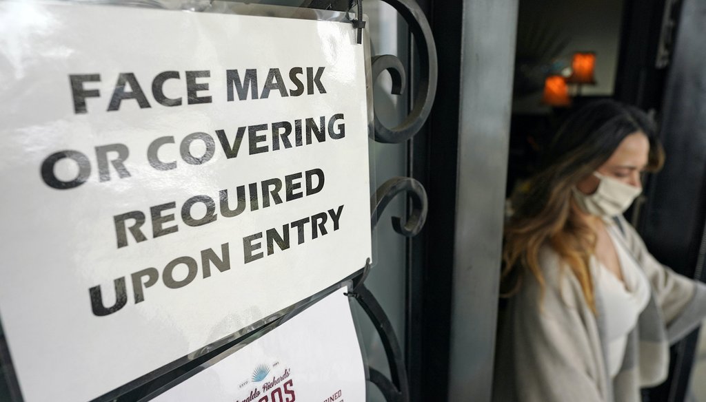 A sign asking customers to wear a face covering is displayed at the entrance to Picos restaurant Wednesday, March 10, 2021, in Houston. (AP Images)