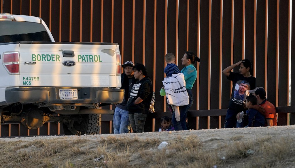 A U.S. Customs and Border Protection vehicle is seen next to migrants after they were detained and taken into custody, March 21, 2021, in Abram-Perezville, Texas. (AP)