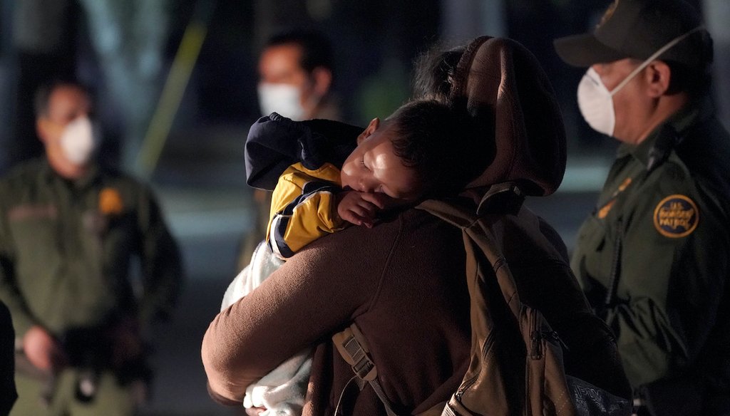 A migrant child sleeps on the shoulder of a woman at an intake area after turning themselves in upon crossing the U.S.-Mexico border, March 24, 2021, in Roma, Texas. (AP)