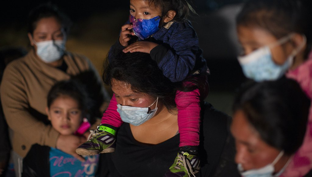 Migrant families coming from Guatemala, wait at a U.S. Border Patrol intake site after they were smuggled on an inflatable raft across the Rio Grande river in Roma, Texas, March 24, 2021.