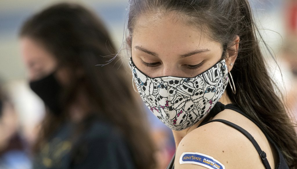 Kent State University student Regan Raeth of Hudson, Ohio, looks at her vaccination bandage as she waits for 15 minutes after her shot in Kent, Ohio, on April 8, 2021. (AP/Long)