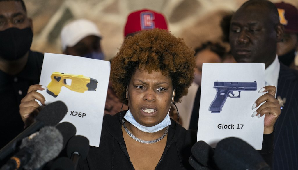 Naisha Wright, aunt of the deceased Daunte Wright, holds up images depicting X26P Taser and a Glock 17 handgun during a news conference at New Salem Missionary Baptist Church, April 15, 2021, in Minneapolis. (AP)