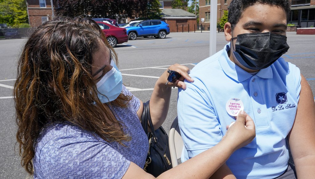 Kendy Marte, left, places a sticker on her son Stanley Pena, 13, after he received the first dose of the Pfizer COVID-19 vaccine at the De La Salle School, on May 14, 2021, in Freeport, N.Y. (AP)