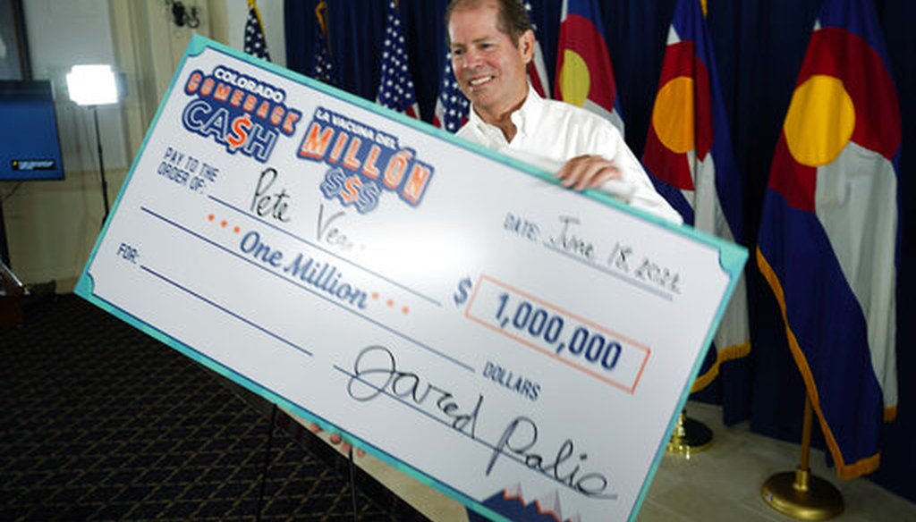 Peter Vegas of Boulder, Colo., takes a super-sized check after he was named the third of five weekly $1 million winners for being vaccinated against COVID-19 on June 18, 2021. (AP)