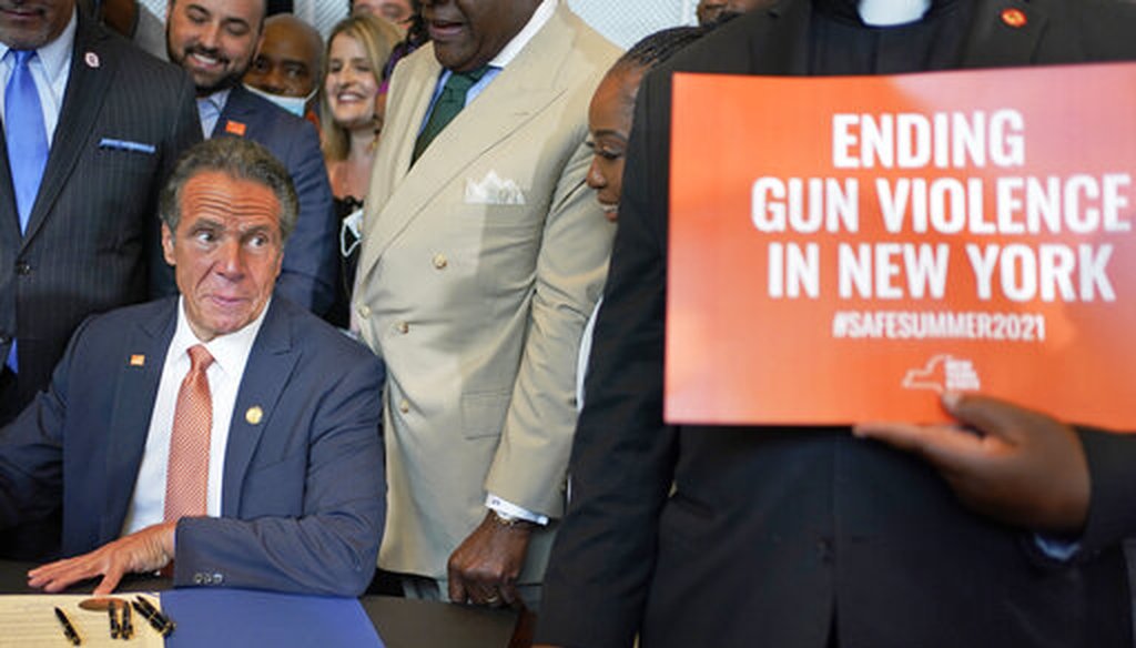 Surrounded by supporters and advocates, New York Gov. Andrew Cuomo signs legislation on gun control in New York on July 6, 2021. (AP)