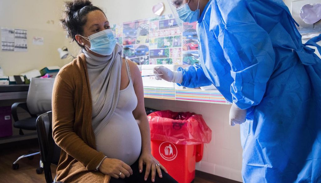 A nurse gives a shot of the Pfizer vaccine for COVID-19 to a pregnant woman in Montevideo, Uruguay, on June 9, 2021. (AP/Campodonico)