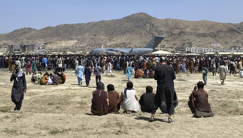 Hundreds of people gather near a U.S. Air Force C-17 transport plane at the perimeter of the international airport in Kabul, Afghanistan on Aug. 16, 2021. (AP/Rahmani)