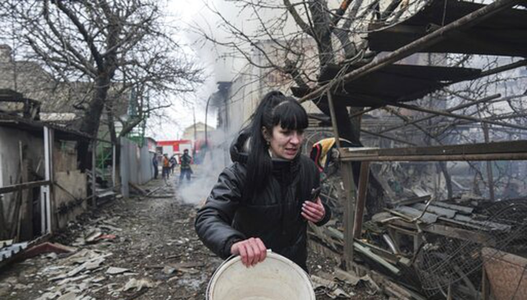 A woman walks past the debris in the aftermath of Russian shelling in Mariupol, Ukraine, on Feb. 24, 2022. (AP)