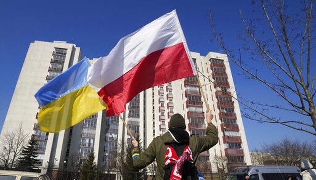 A man waves the Ukrainian and Polish flag during a demonstration in front of a building housing Russian diplomats in Warsaw, Poland,  on March 13, 2022. (AP)