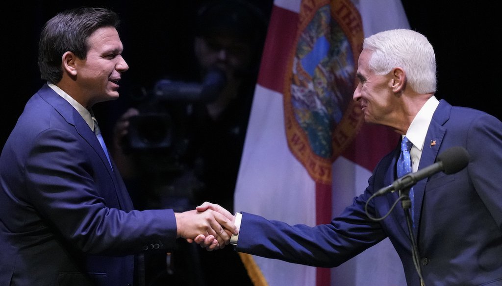 El gobernador republicano de Florida, Ron DeSantis, a la izquierda, le da la mano a su oponente demócrata Charlie Crist al comienzo de su debate televisado, en el Teatro Sunrise en Fort Pierce, Florida, el 24 de octubre de 2022. (AP)
