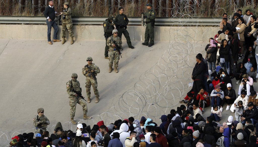Migrants congregate on the banks of the Rio Grande at the U.S. border with Mexico Dec. 20, 2022, where members of the Texas National Guard cordoned off a gap in the U.S. border wall. (AP)