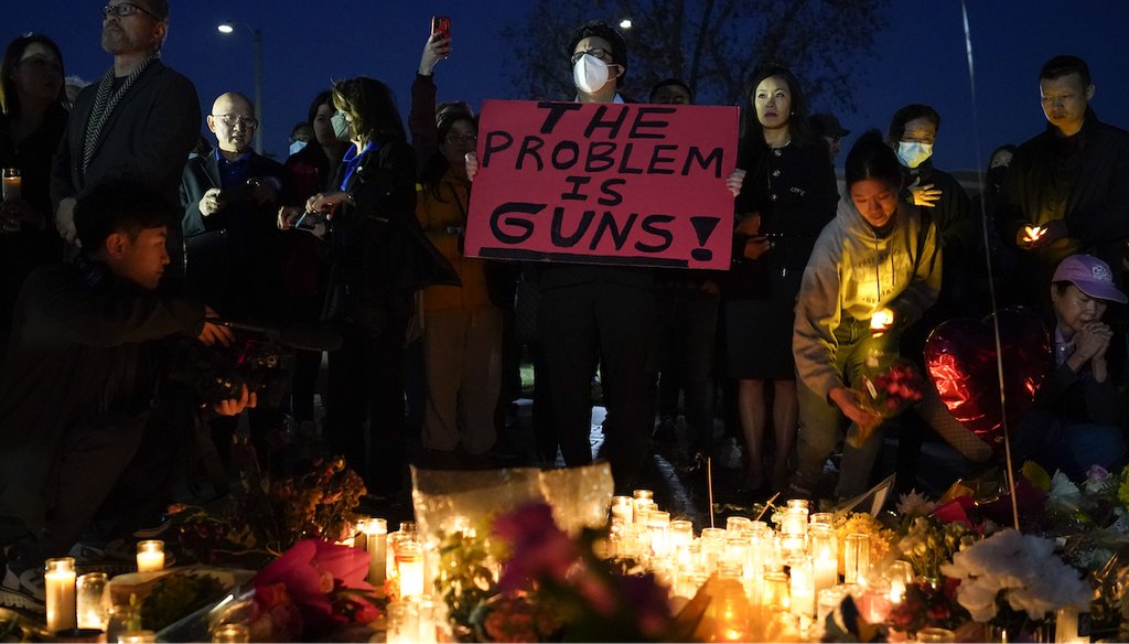 A man holds a sign during a vigil outside Monterey Park City Hall, blocks from the Star Ballroom Dance Studio, on Jan. 24, 2023, in Monterey Park, Calif. A gunman killed multiple people at the ballroom dance studio late Saturday. (AP)