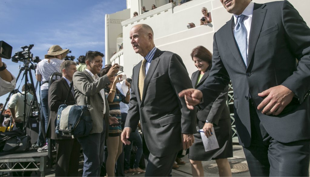 California Gov. Jerry Brown, center, arrives with Senate President pro Tempore Kevin De Leon, D-Los Angeles, right, and Assembly speaker Toni Atkins, second from right, to sign landmark legislation SB 350 to combat climate change. Damian Dovarganes / AP