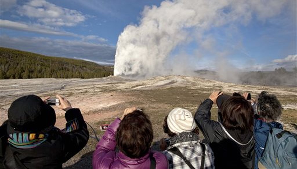 In this May 21, 2011 file photo, tourists photograph Old Faithful erupting, at Yellowstone National Park, in Mont. Old Faithful is among the park’s hydrothermal features powered by the Yellowstone supervolcano. (AP Photo/Julie Jacobson,File)