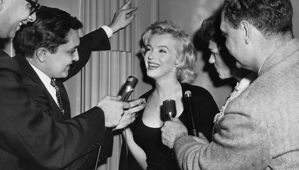 Marilyn Monroe questioned by news reporters in New York City.