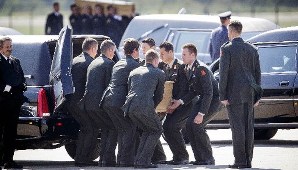 Pallbearers place a coffin into a hearse during a ceremony to mark the return of the first bodies of passengers and crew killed in the downing of Malaysia Airlines Flight 17, at Eindhoven military air base, Netherlands. (AP)
