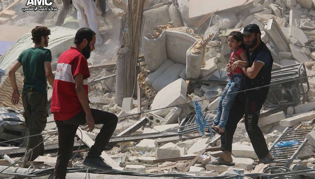 This photo provided by the Syrian anti-government activist group Aleppo Media Center (AMC), shows a Syrian man carrying a girl away from the rubble of a destroyed building after barrel bombs were dropped on the Bab al-Nairab neighborhood in Aleppo, Syria.