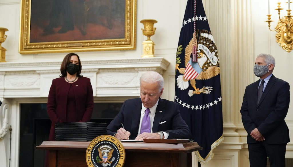 President Joe Biden signs executive orders alongside Vice President Kamala Harris and Dr. Anthony Fauci, director of the National Institute of Allergy and Infectious Diseases, in the White House on Jan. 21, 2021, in Washington. (AP/Brandon)