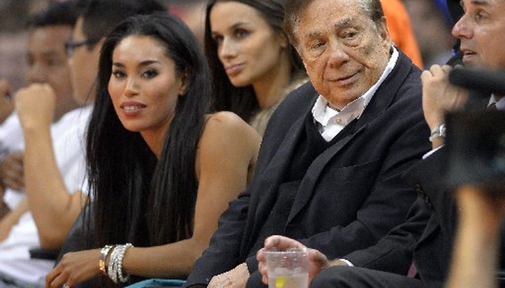 Los Angeles Clippers owner Donald Sterling, right, and V. Stiviano, left, watch the Clippers play the Sacramento Kings during the first half of an NBA basketball game in Los Angeles. (AP)