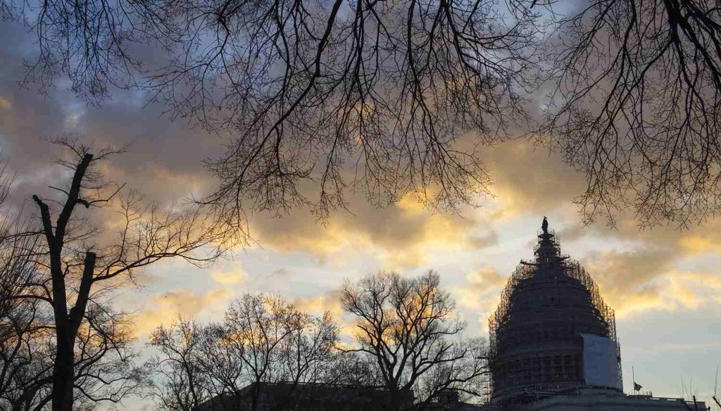 The sun rises over the Capitol, covered in scaffolding for repairs, in Washington on Jan. 5, 2015.