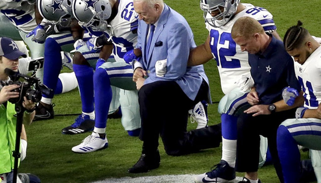 The Dallas Cowboys, led by owner Jerry Jones, center, take a knee prior to the national anthem before an NFL football game against the Arizona Cardinals in Glendale, Ariz.,  Sept. 25, 2017. (Associated Press).