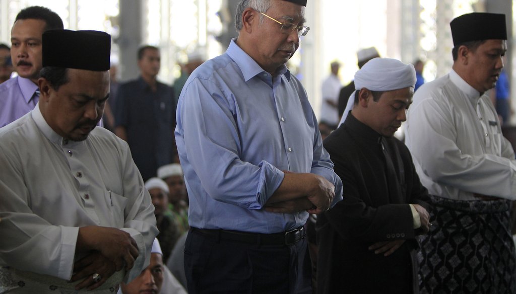 The missing Malaysian airliner is a mystery with evolving leads every day. Here, Malaysian Prime Minister Najib Razak (second from left, prays at a mosque in Sepang, Malaysia, on March 14, 2014. (AP photo)