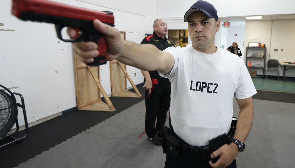 In this July 16, 2019, photo, Fernando Lopez, of the Othello Police Department in Othello, Wash., holds a training gun as he takes part in a firearms defense class as part of Washington state's Basic Law Enforcement Academy in Burien, Wash. (AP)