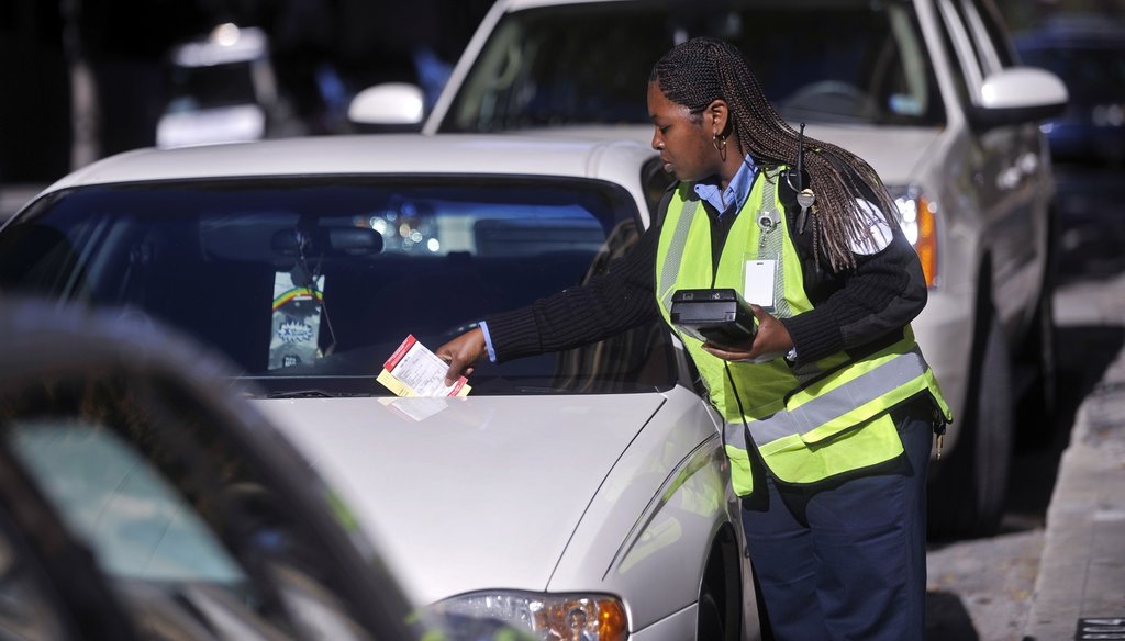 A PARK-atlanta agent leaves a ticket on the windshield of a car with an expired metered space in 2010 in downtown Atlanta. AJC file photo